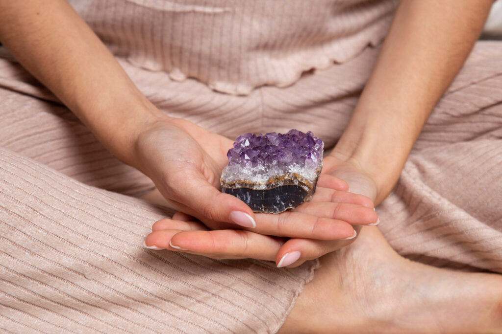 Imagem ilustrativa sobre a energia dos cristais mostrando uma aluna da Escola de Magia usando um quartzo para equilibrar suas energias.