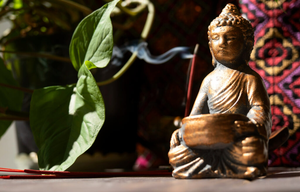 Imagem ilustrando o conteúdo sobre karma e dharma, conceitos originários do budismo, mostrando uma estatueta de Buda.