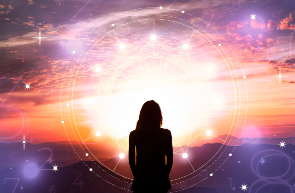 Imagem ilustrando o conteúdo sobre arquétipos mostrando uma mulher de frente para um céu muito iluminado e colorido, ornamentado com ícones de astrologia, numerologia e afins.